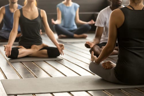 Group of young sporty people practicing yoga lesson with instructor-img-blog