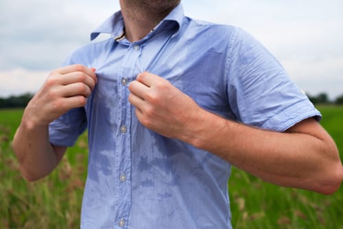 man with hyperhidrosis sweating very badly under armpit in blue shirt-img-blog