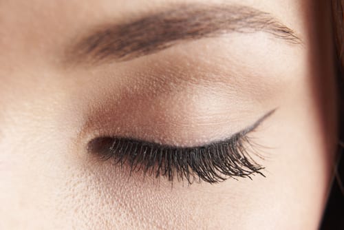 close up of womans brown eye lid with false eye lashes-img-blog