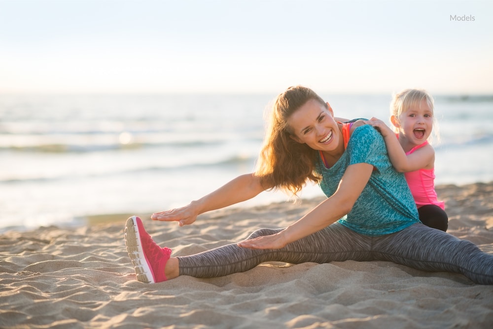 happy mother exercising to maintain her mommy makeover procedure.