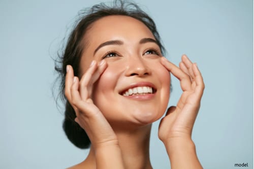 Woman admiring her clear skin as a result of healthy skin habits