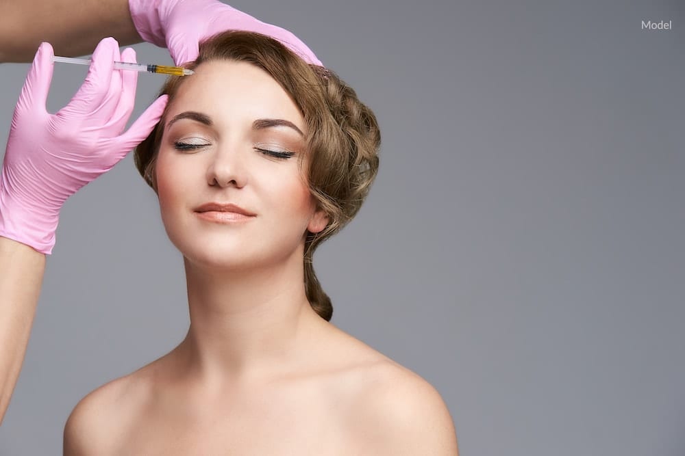 A young woman having a liquid facelift procedure performed.