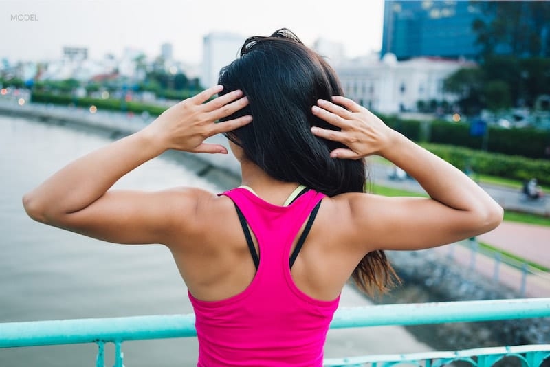 Active woman showing off her tight upper arms from the back.