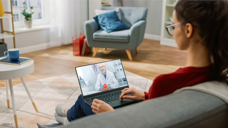 Woman undergoing a virtual consultation with her doctor from the comfort of her home.