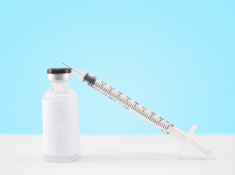 Syringe sitting on top of medication bottle