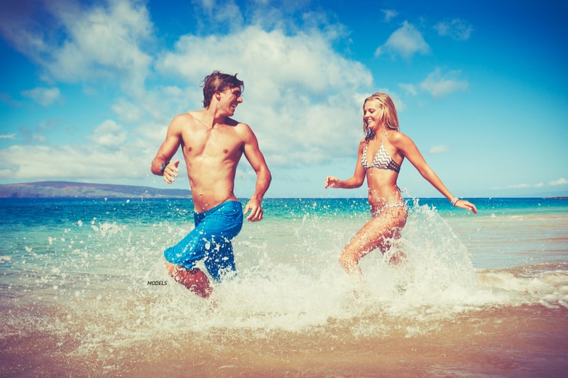 Man and woman, running along the beach.