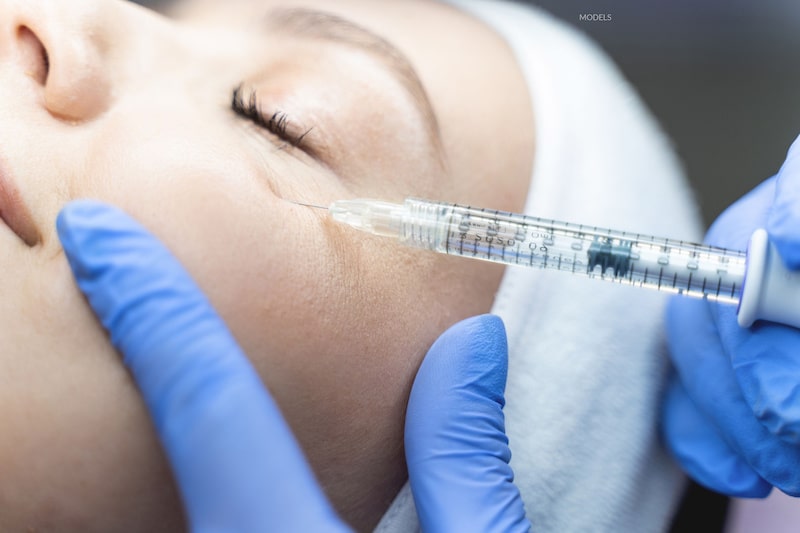 Female patient receiving dermal filler injection under her eye