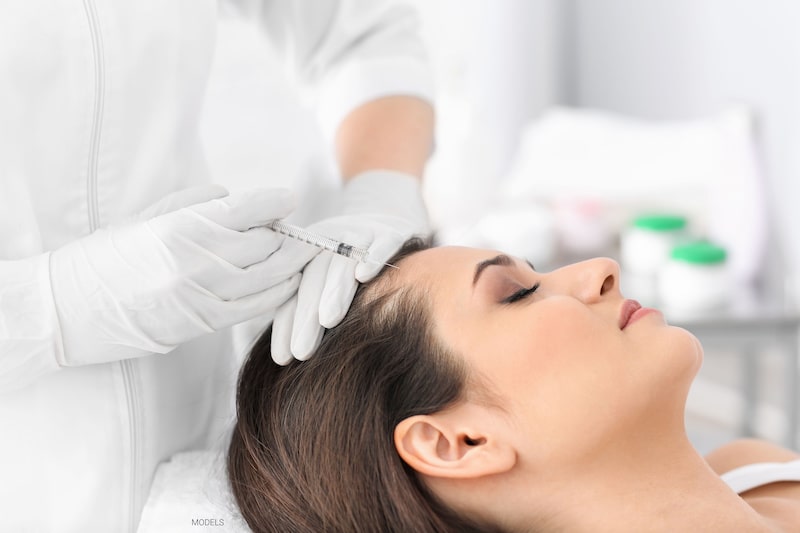 A woman receives an injection of PRP for hair loss treatment.