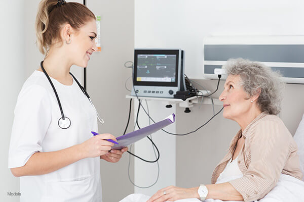 An older woman is attended to in a hospital.