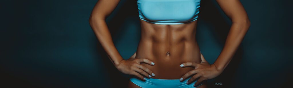 Cropped image of woman's sculpted abdominal muscles
